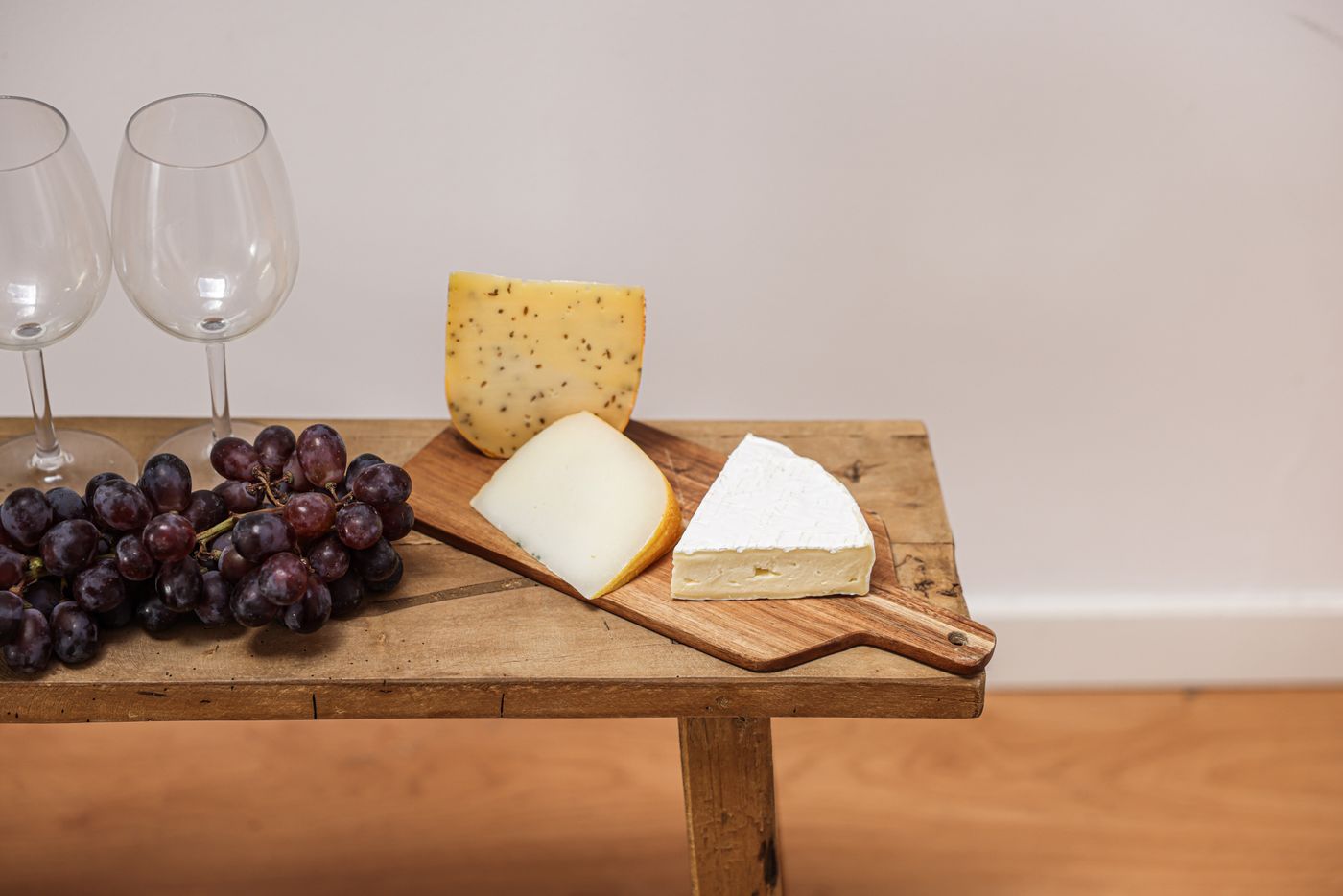 A bloomy-rind round on a board with young gouda