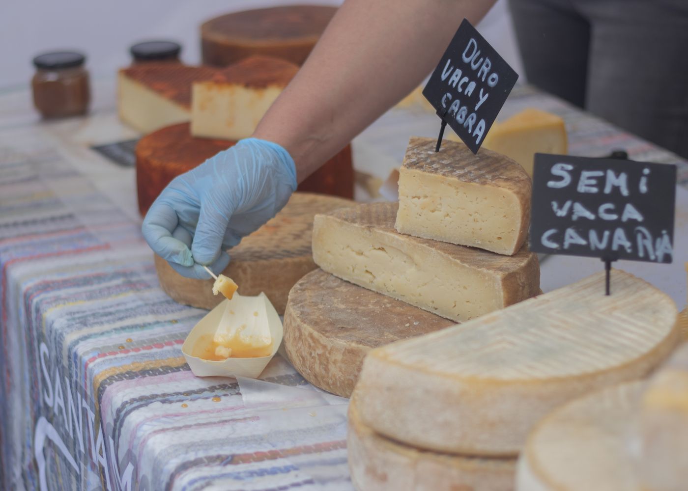 Rust-orange washed-rind wheels at a market stall